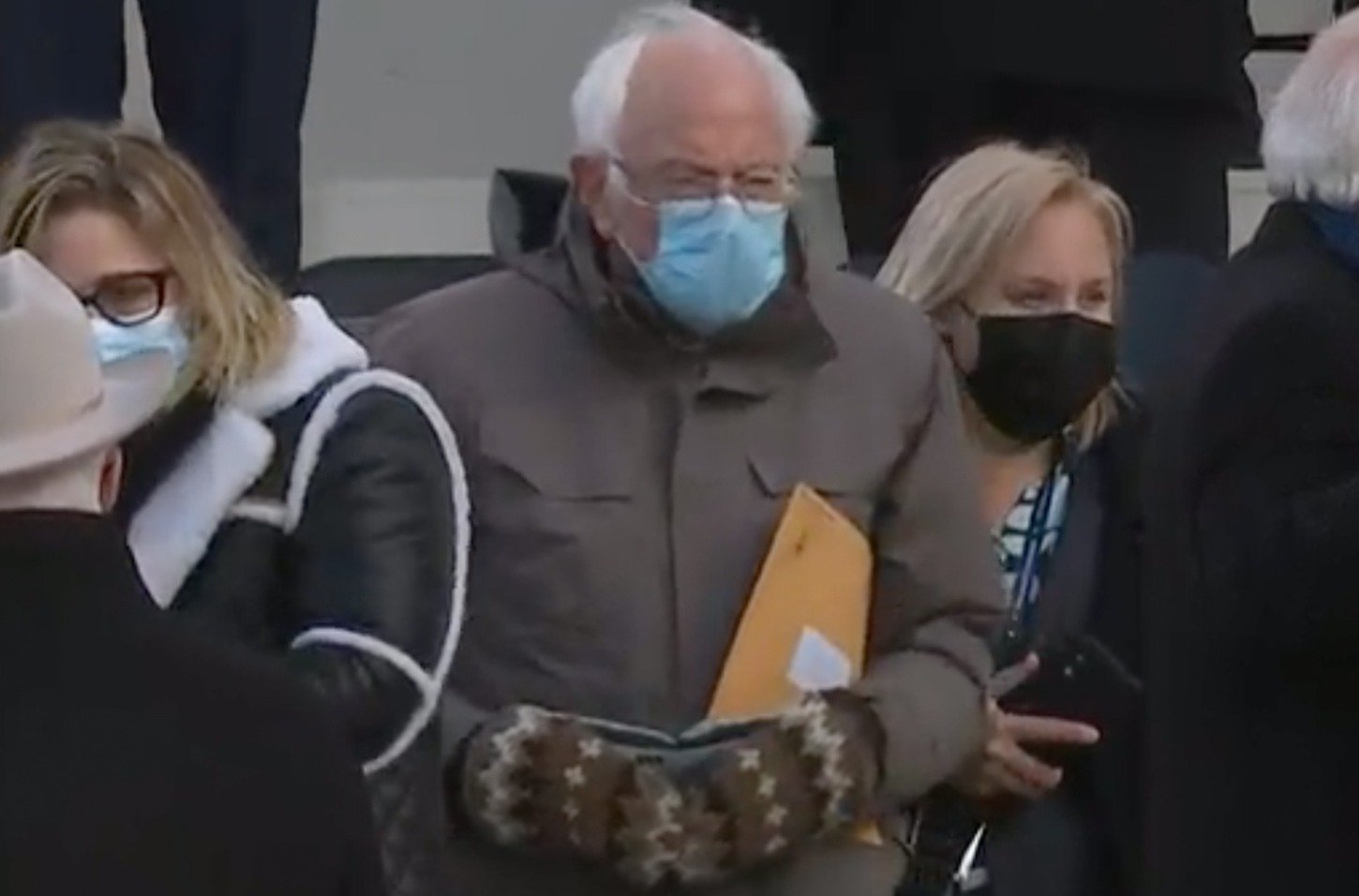 A screenshot of Senator Bernie Sanders holding an envelope at President Joe Biden's Inauguration