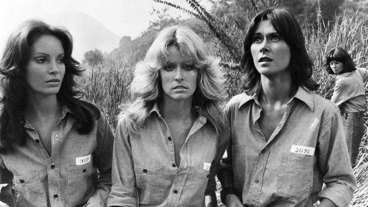 Jaclyn Smith, Farrah Fawcett, and Kate Jackson in a black and white set photo from Charlie's Angels