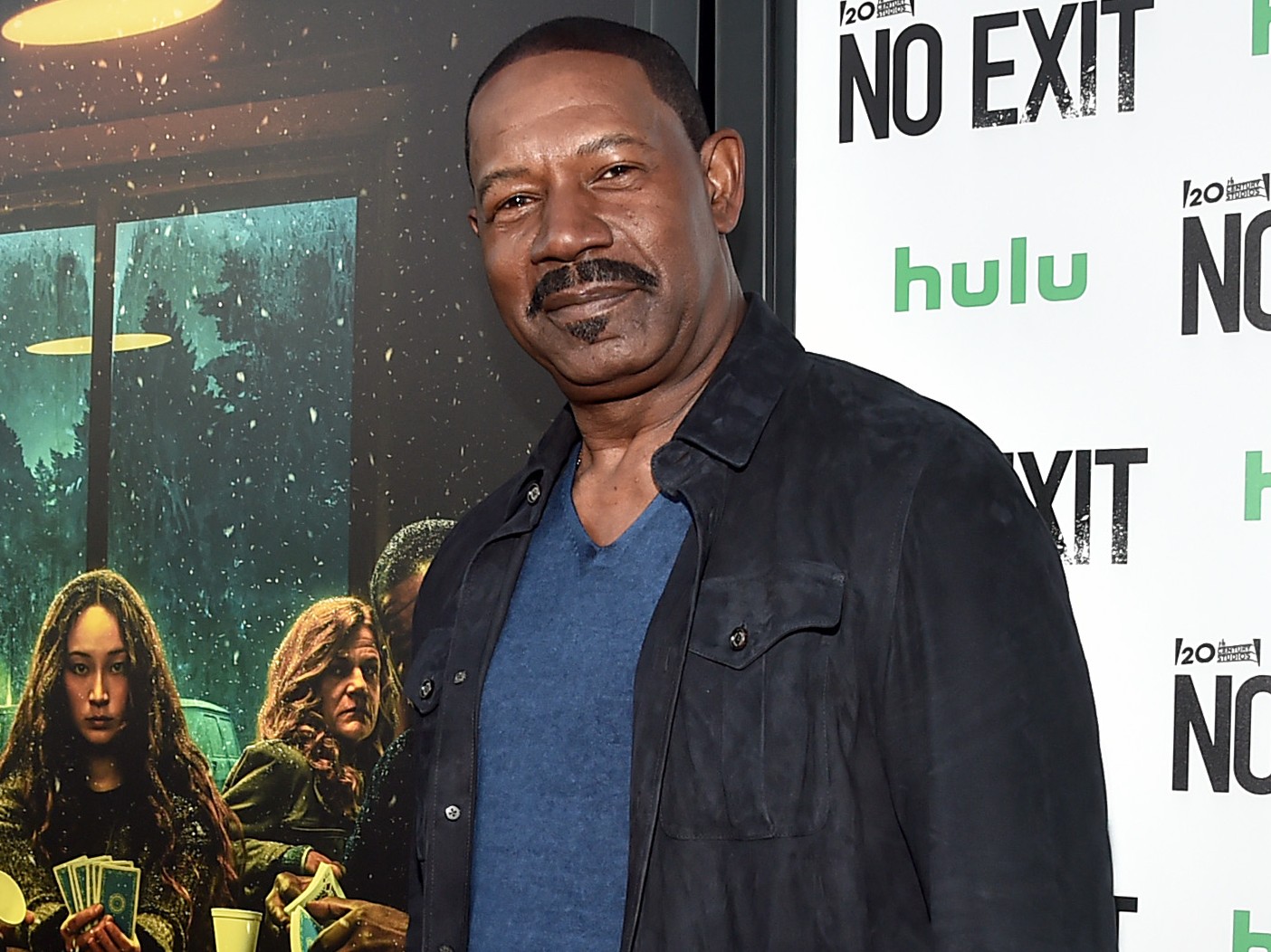 Dennis Haysbert on the red carpet wearing blue top and black jacket