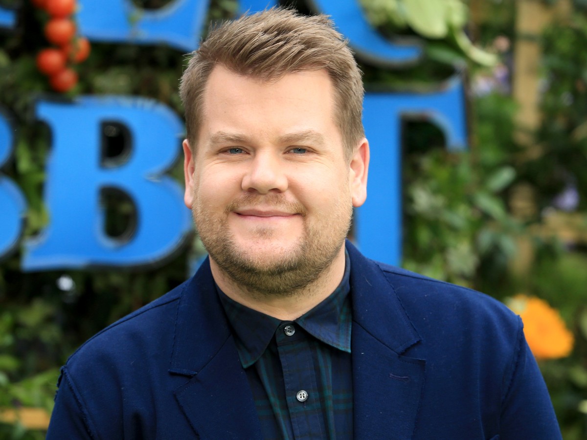 James Corden smiles in navy blue suit jacket